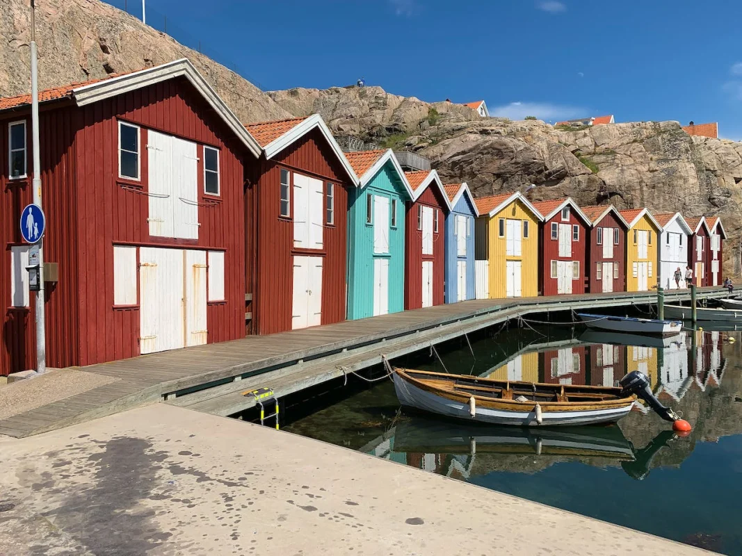 Röda sjöbodar och en eka vid bryggan i en svensk hamn
